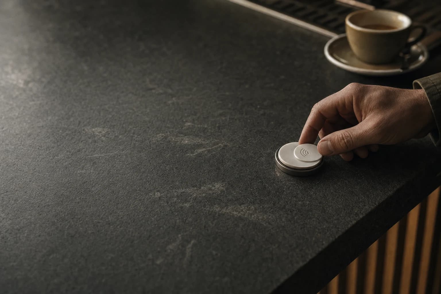 A customer taps a small NFC reader at a café counter